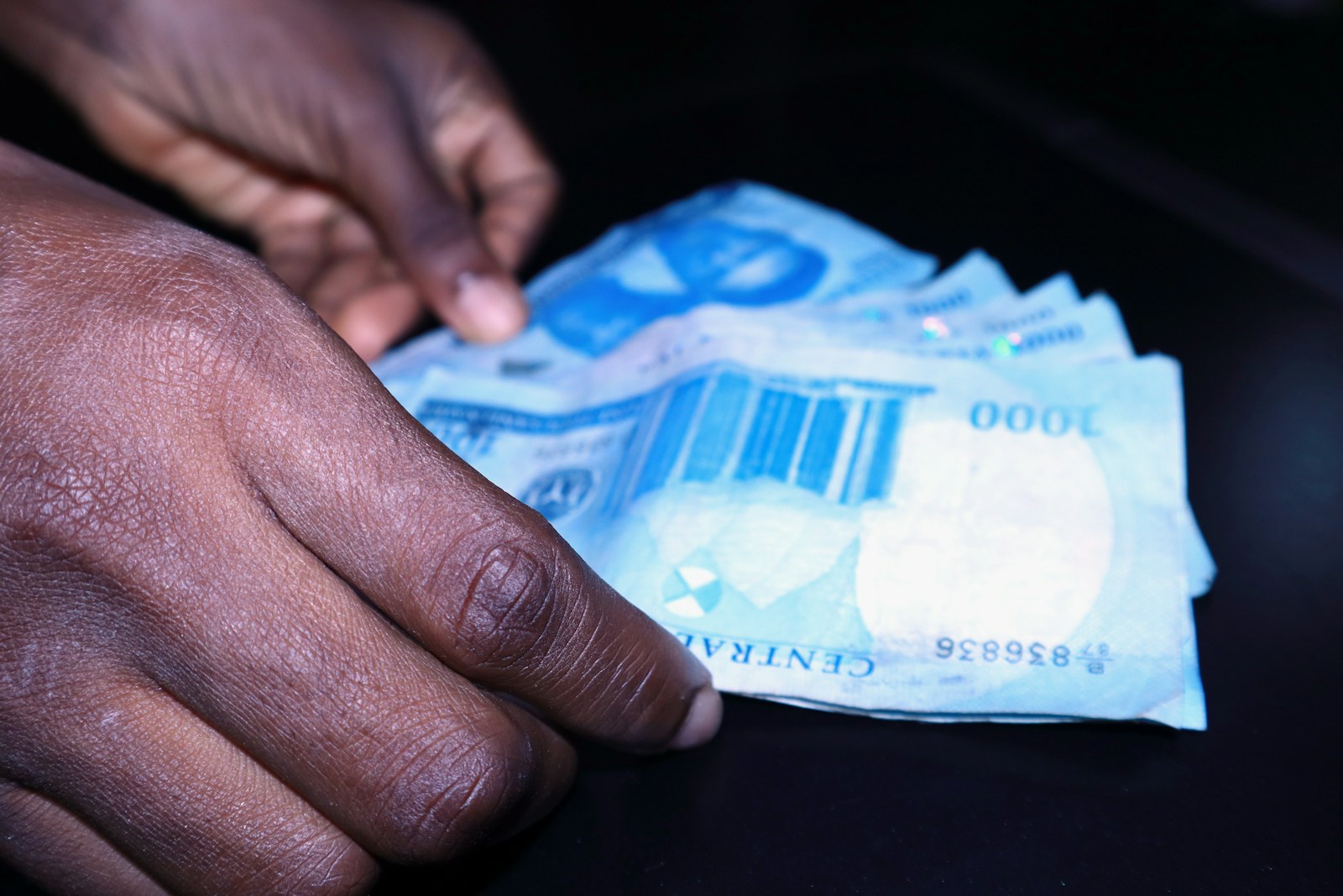 South Africa scam: a person's hand reaching for a piece of paper money